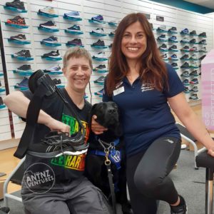 Antnz on left and Claudia on the right, crouching on ground. ADNZ Raven is sitting between them. Raven has her ears pulled back looking scatterbrained (she'd been licking at my face). Antnz is holding a new black running shoe with a brace attached.