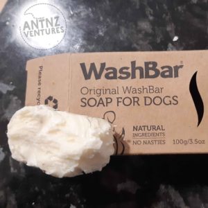 Picture Description: A picture of a brown recycled cardboard box with a chewed piece of soap about 1/3 of the box size. The cardboard box reads in bold at the top left "WashBar". Then below and smaller font "Original WashBar". Then below smaller bold font in Caps "SOAP FOR DOGS". The chewed soap takes up the final 1/3 of the lower box. Next to the soap the box reads "Natural Ingredients, No Nasties".