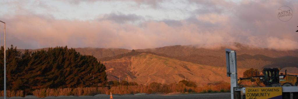 A landscape of a mountain range with a slight cloud cover on the tops. The light is diffused and low to the horizon which bring a glow to the image.