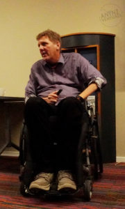 A picture of a pakeha man in a wheelchair, he is clean shaven with blond hair.