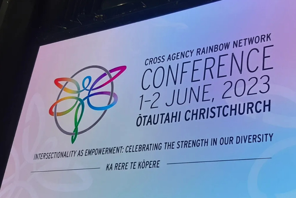 A banner for the Cross-Agency Rainbow Network Conference. The logo is a rainbow stylized dragonfly and is next to text with the conference details.