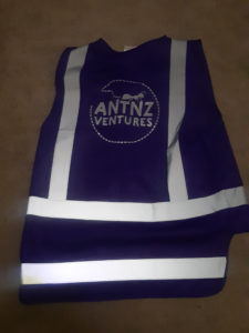 A purple High Visibility Vest with reflective strips and AntnzVentures logo